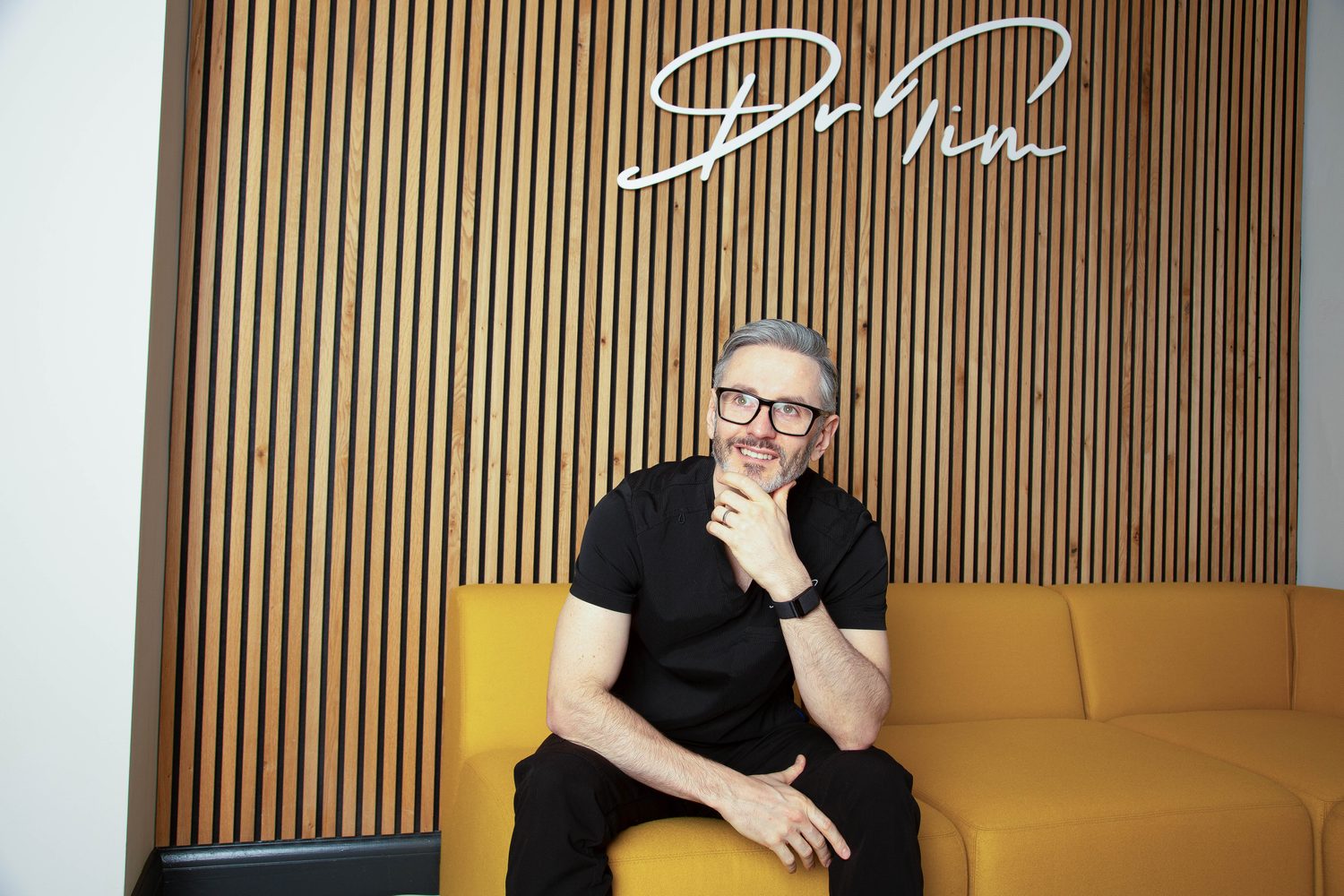 Dr Tim Pearce seated beneath his signature wall in the Profinity Wellness clinic